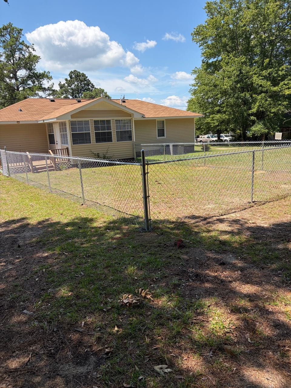 Galvanized chain link fence around the back yard of a house